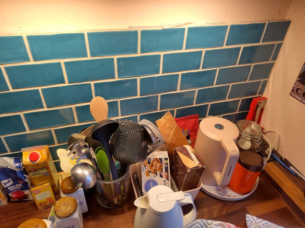 blue tile backsplash in cluttered kitchen 
