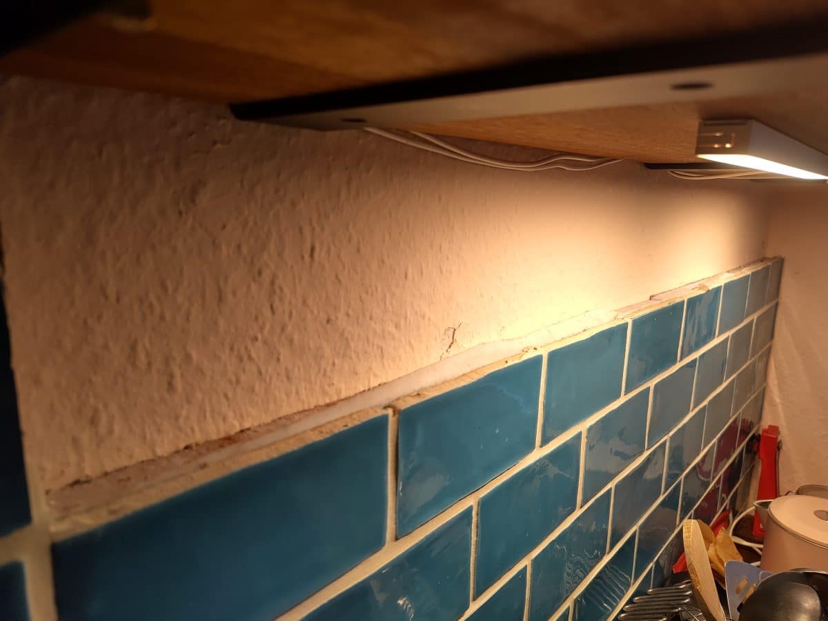 blue tile backsplash in cluttered kitchen 