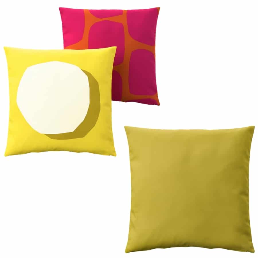 Three decorative throw pillows: two yellow (one with a white geometric circle) and one magenta with orange abstract shapes.