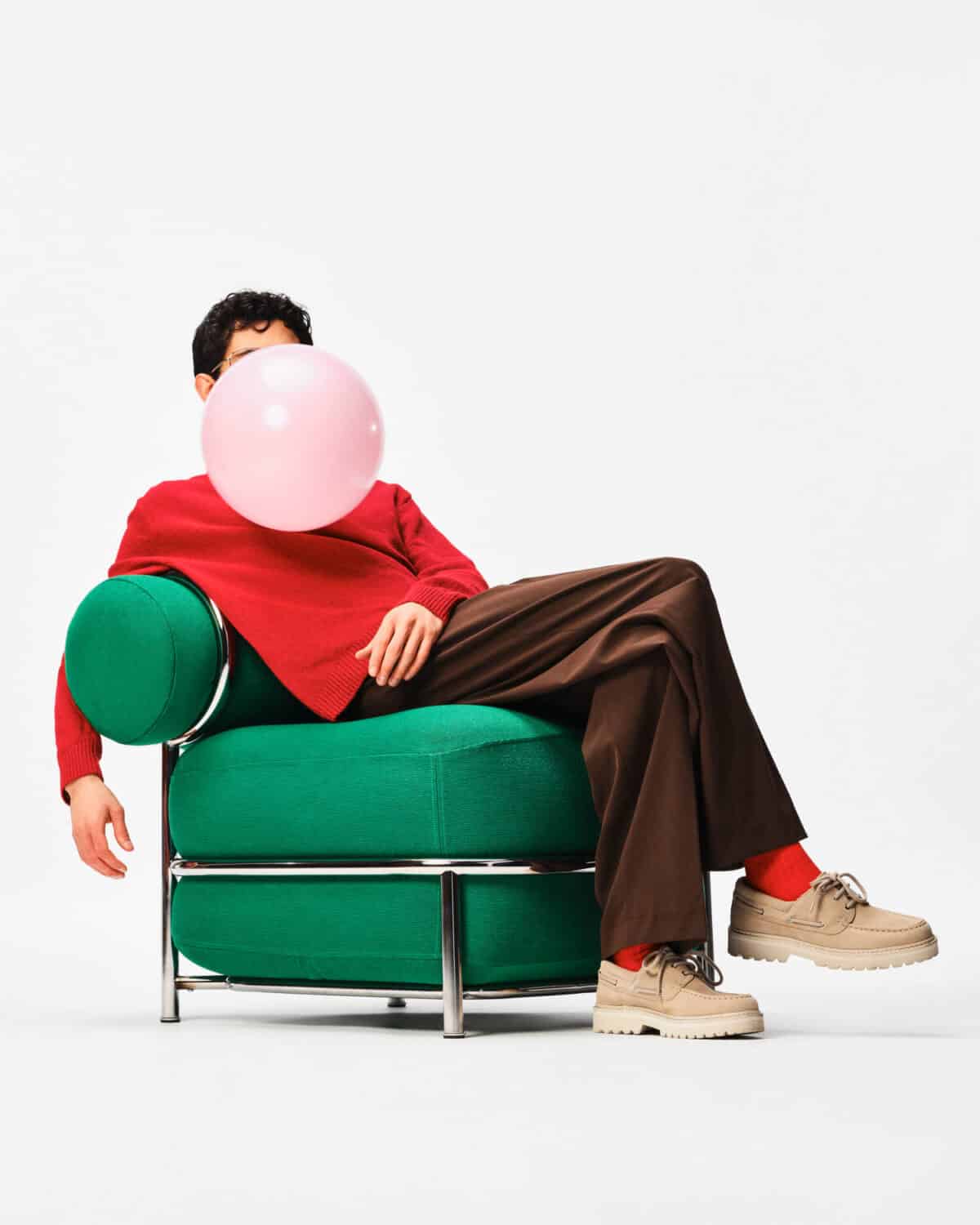 ikea ps 2026 inflatable chair in green with man blowing a balloon while sitting on it.