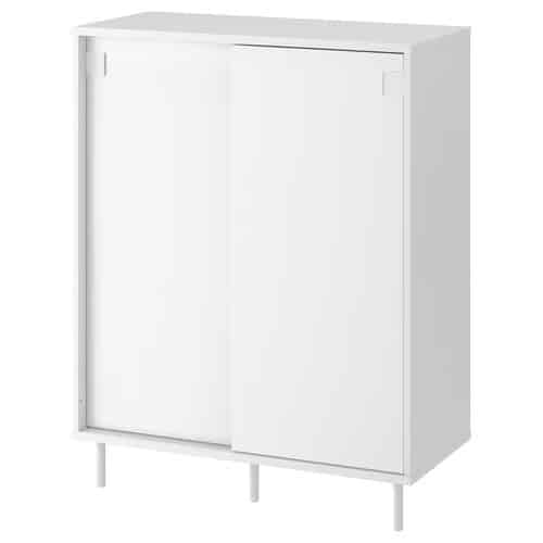 10 - IKEA Hackers White freestanding cabinet with sliding doors and short legs on a plain white background, minimalist storage.