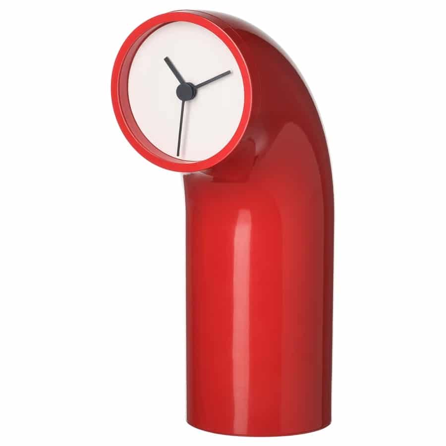 Red curved modern clock sculpture with a white circular clock face at the top. Accessible as a desk clock or decorative timepiece in a contemporary setting.