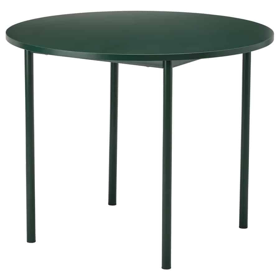 Round dark-green table with four slender legs, viewed from the side.