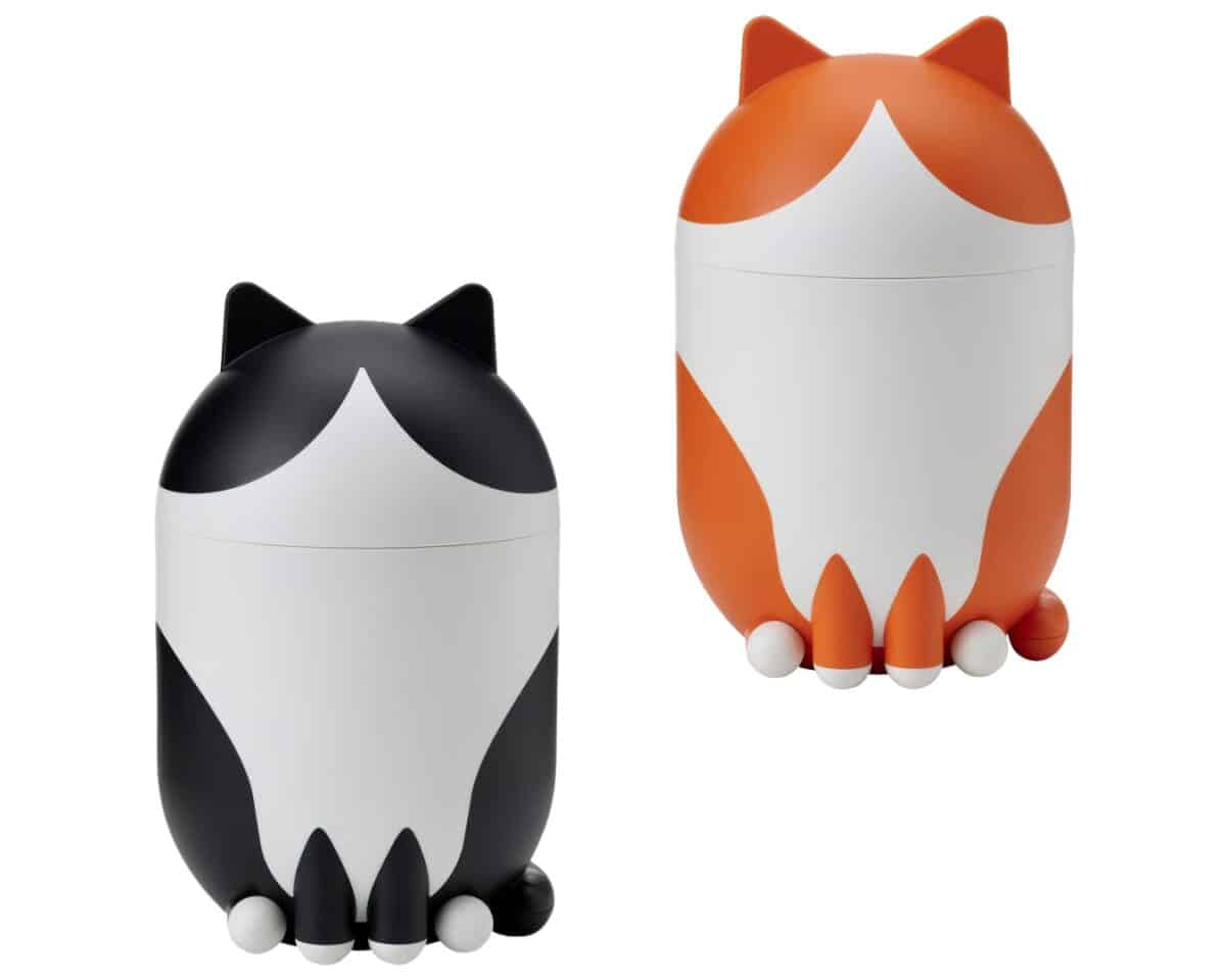 Two cartoon-style cat figurines, one black and white and the other orange and white, sitting upright side by side.