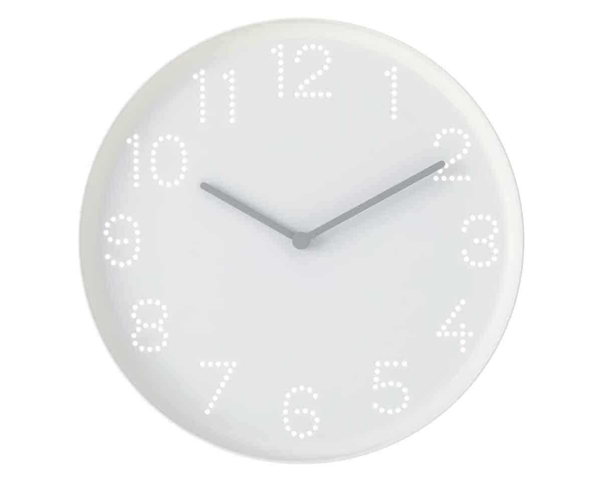 Analog wall clock with dotted numeral markers and gray hands showing about 10:10.
