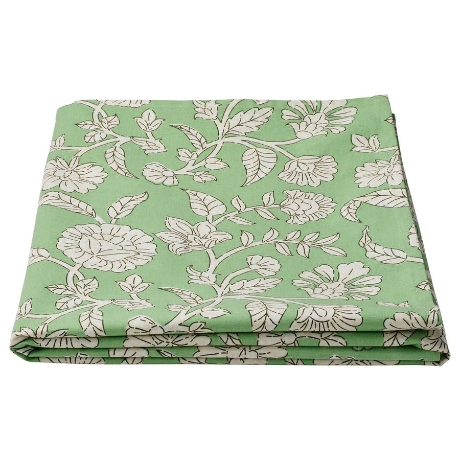 Folded green fabric with a white floral pattern, neatly pressed.