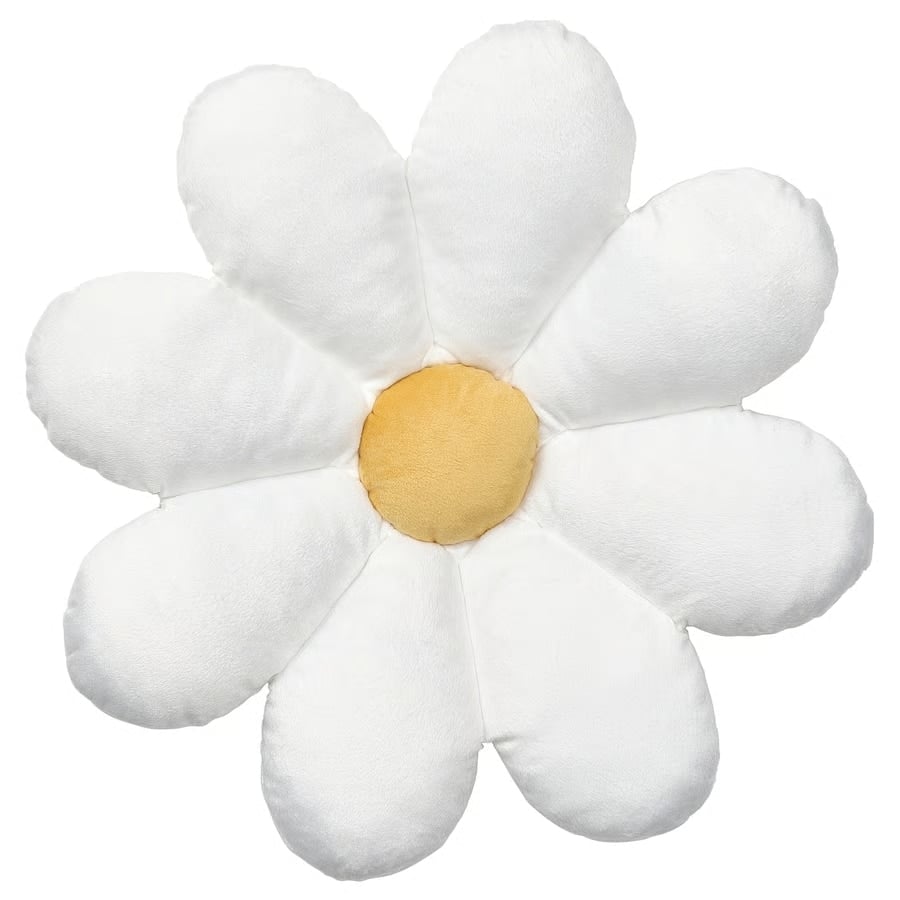 Soft plush daisy-shaped pillow with white petals and a yellow center