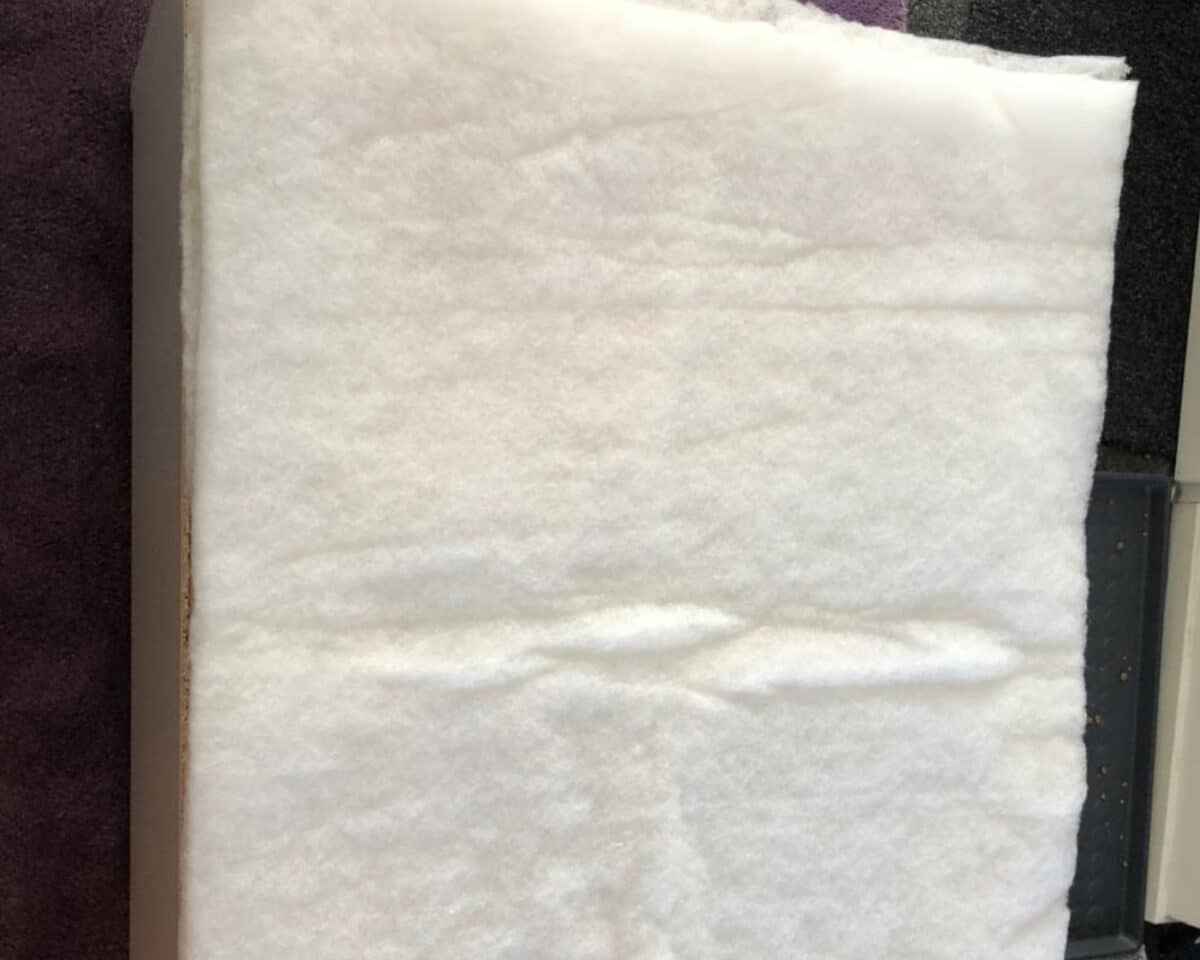 Close-up of a white fluffy towel or tissue sheet laid over a dark surface.