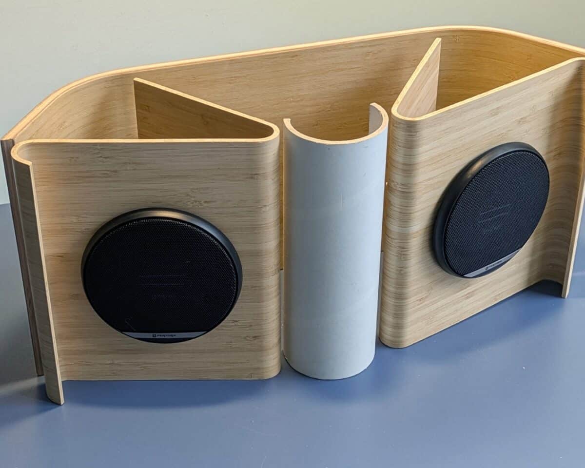 5 - IKEA Hackers Wooden curved speaker cabinet with two round black drivers mounted on each side.