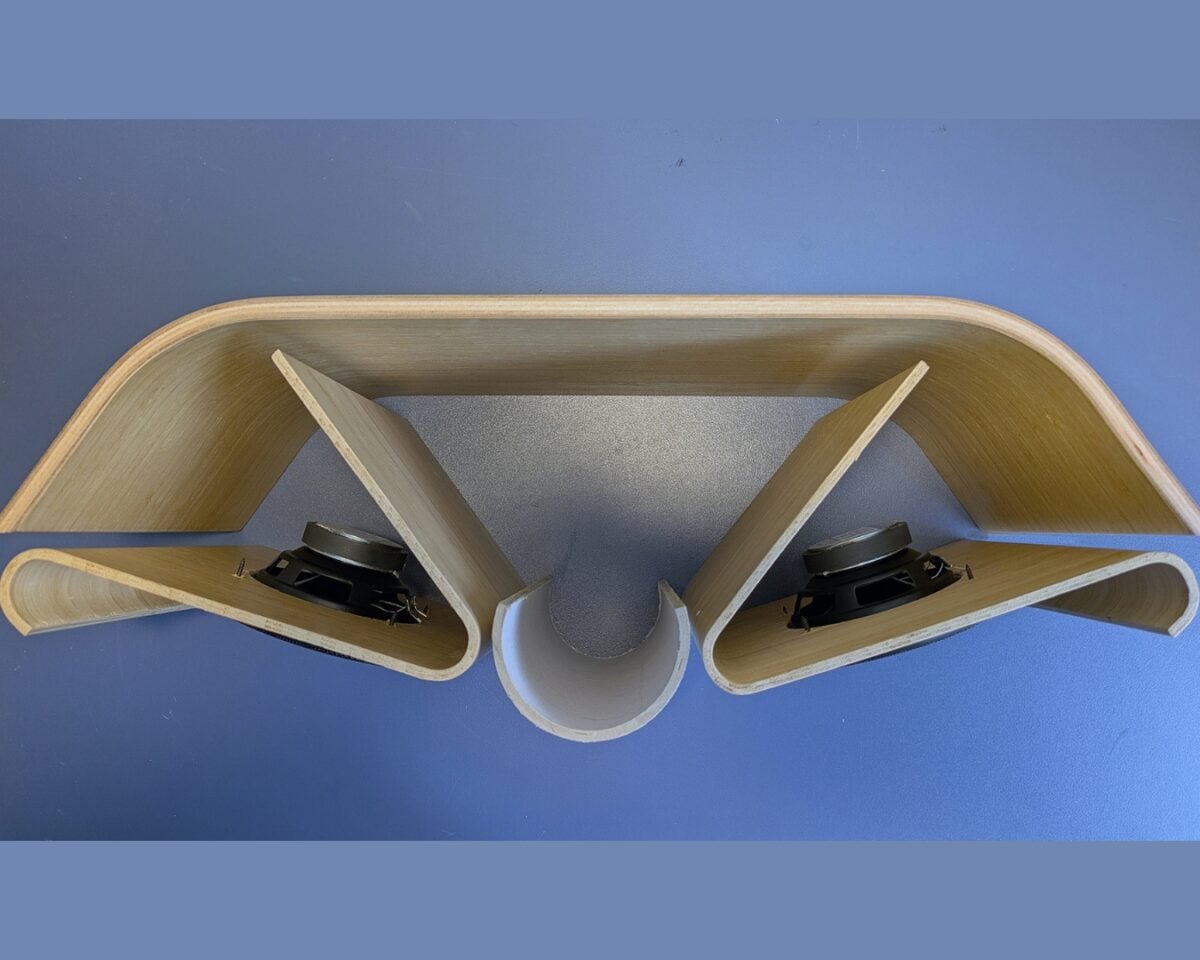 7 - IKEA Hackers Wooden curved panel with two triangular hollows containing small speakers, connected by a central semicircular channel.