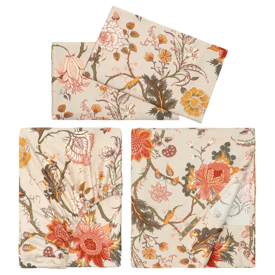 Cream-colored bedding set with pink, orange, and green floral patterns laid flat for display.