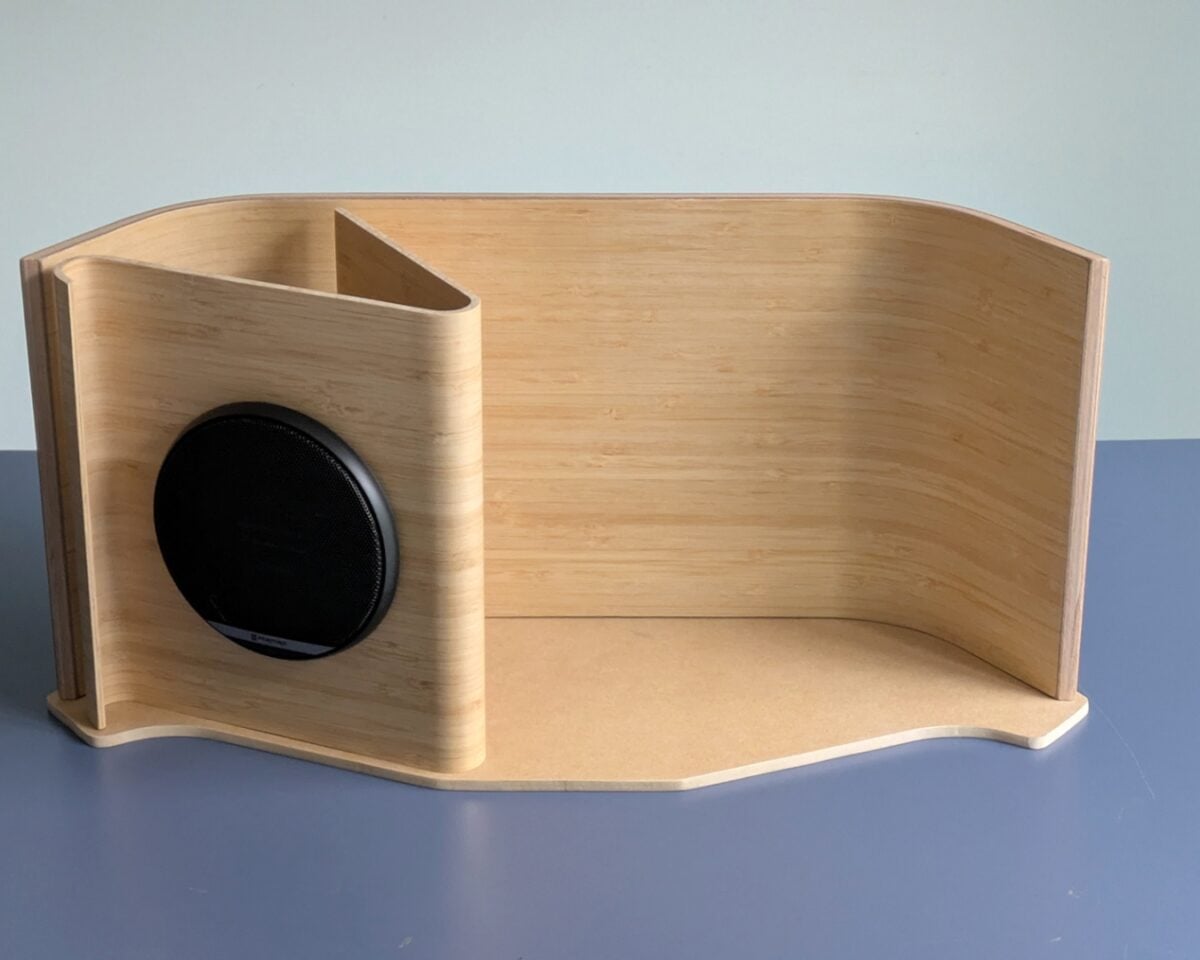 8 - IKEA Hackers Curved wooden speaker enclosure with a large black circular speaker on the left panel.
