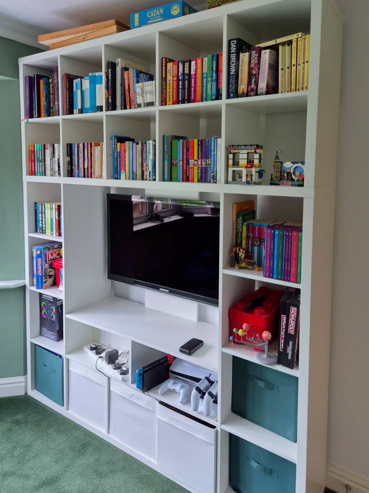 kallax lappland tv unit - IKEA Hackers IKEA KALLAX LAPPLAND playroom storage and TV combo hack. White modular shelving unit filled with colorful books surrounding a mounted TV and small toy/set pieces on the right shelf area.