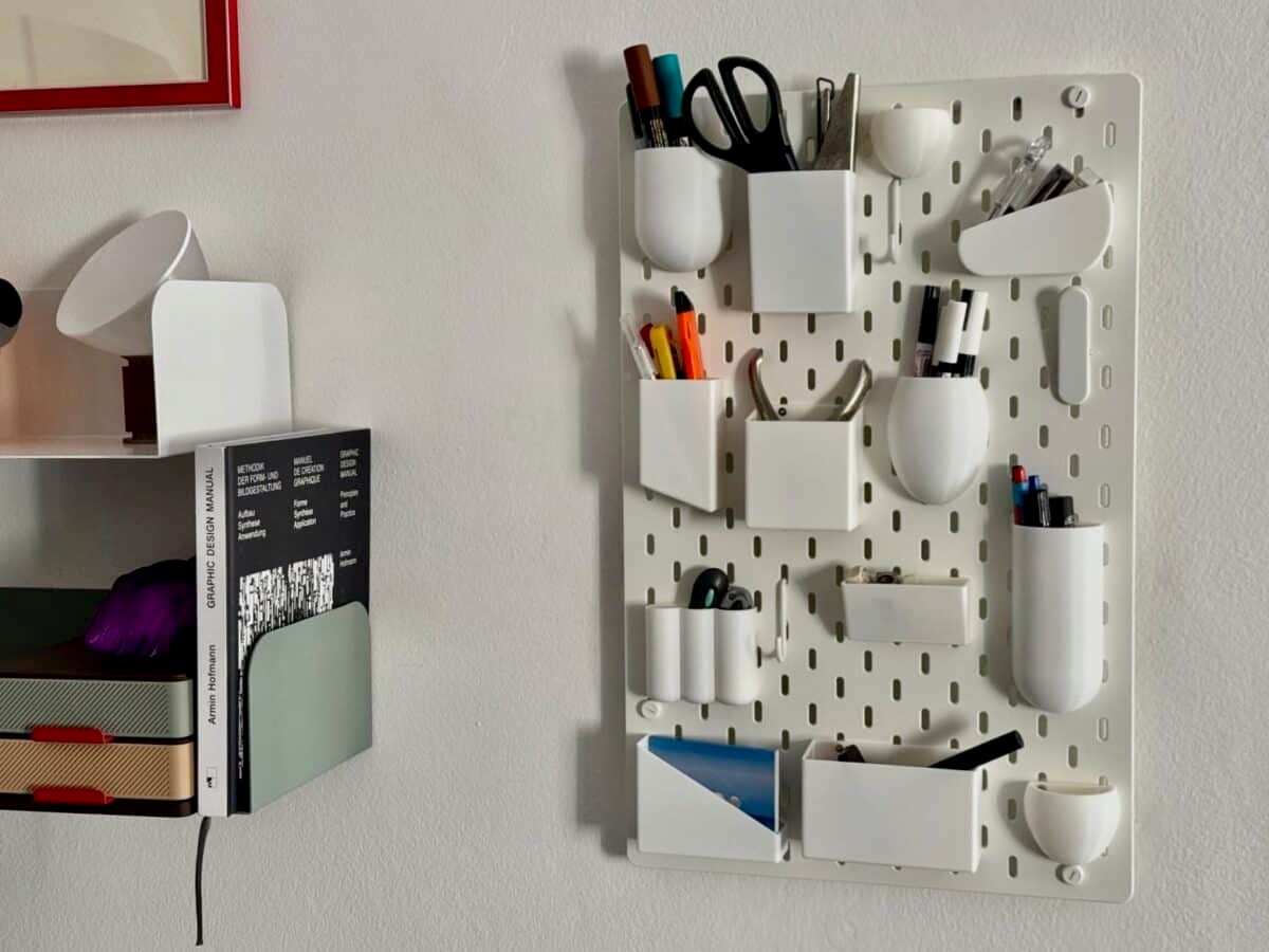 Uten inspired IKEA pegboard - IKEA Hackers White wall pegboard organizer with multiple white cups holding scissors, markers, and small tools for easy desk storage.