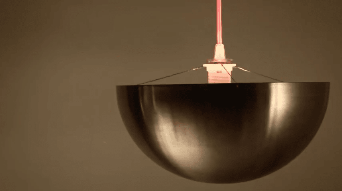 blanda-bowl-lamp - IKEA Hackers Metallic hemispherical pendant light shade suspended by a red cord.