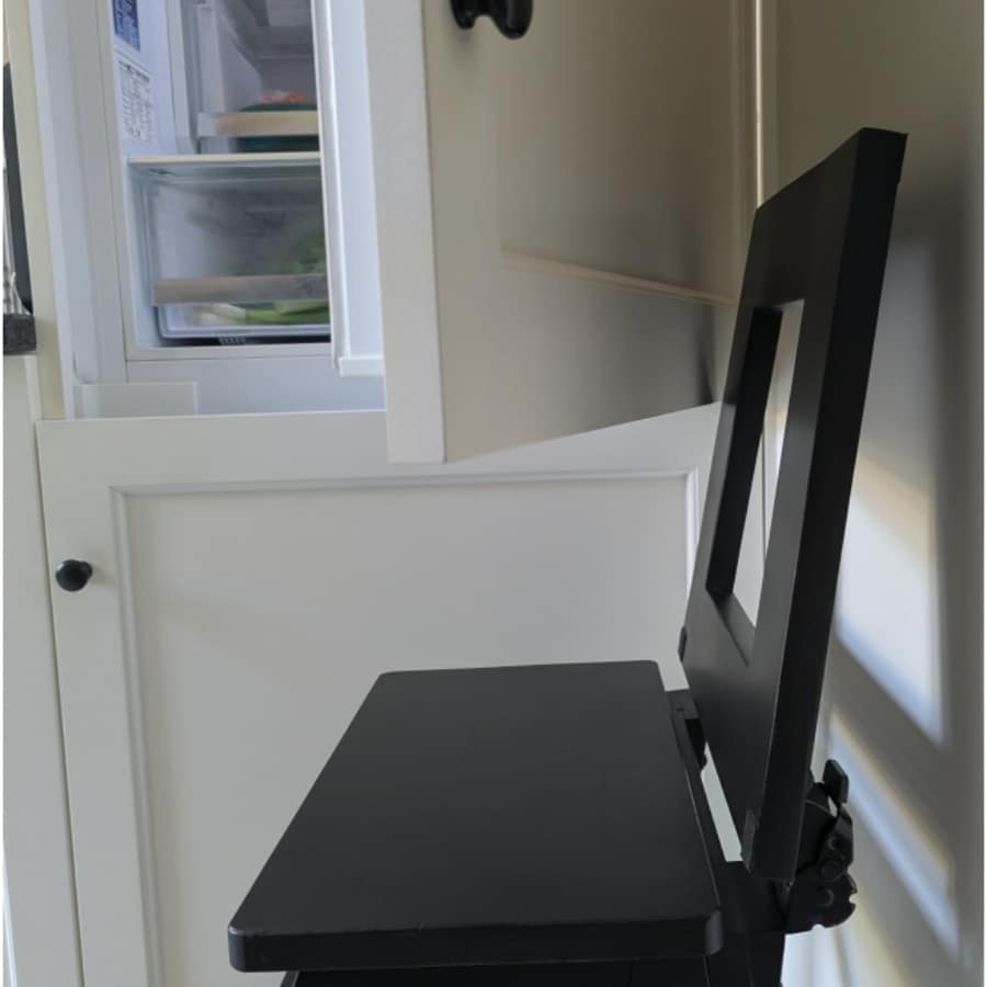 27 - IKEA Hackers Compact black desk with a built-in chair in a kitchen corner; an open refrigerator is visible to the left.