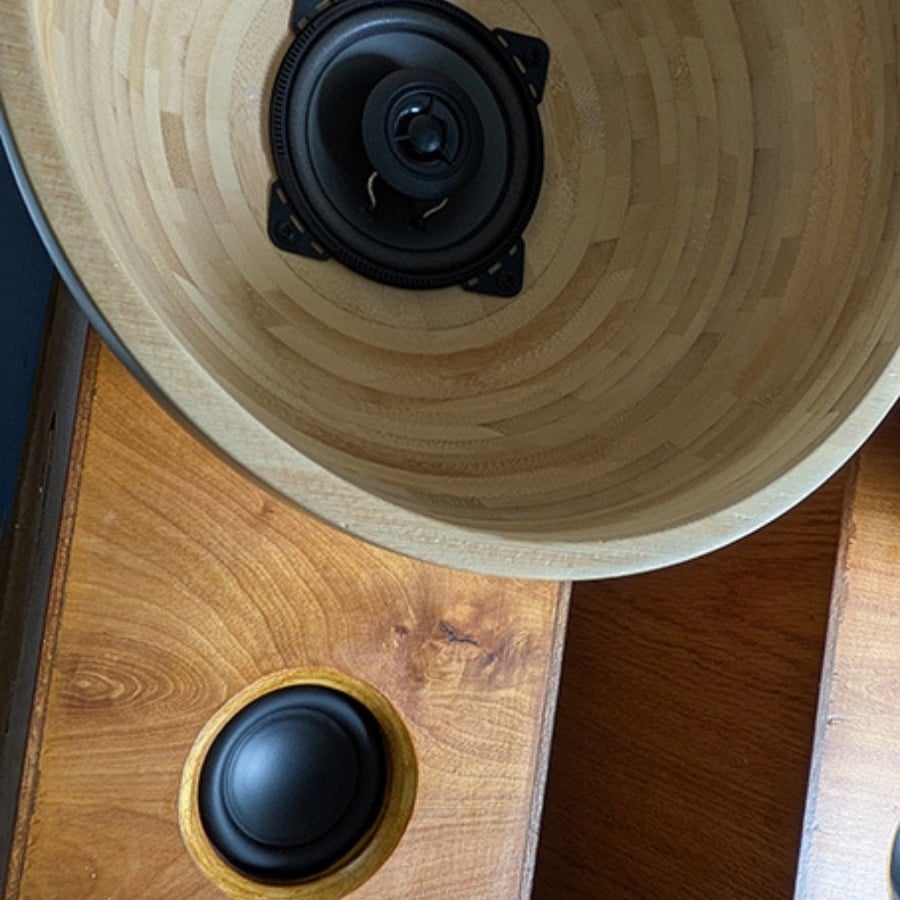 55 - IKEA Hackers Top‑down view of a wooden speaker cabinet with a large round woofer and a smaller circular port on the side panel.