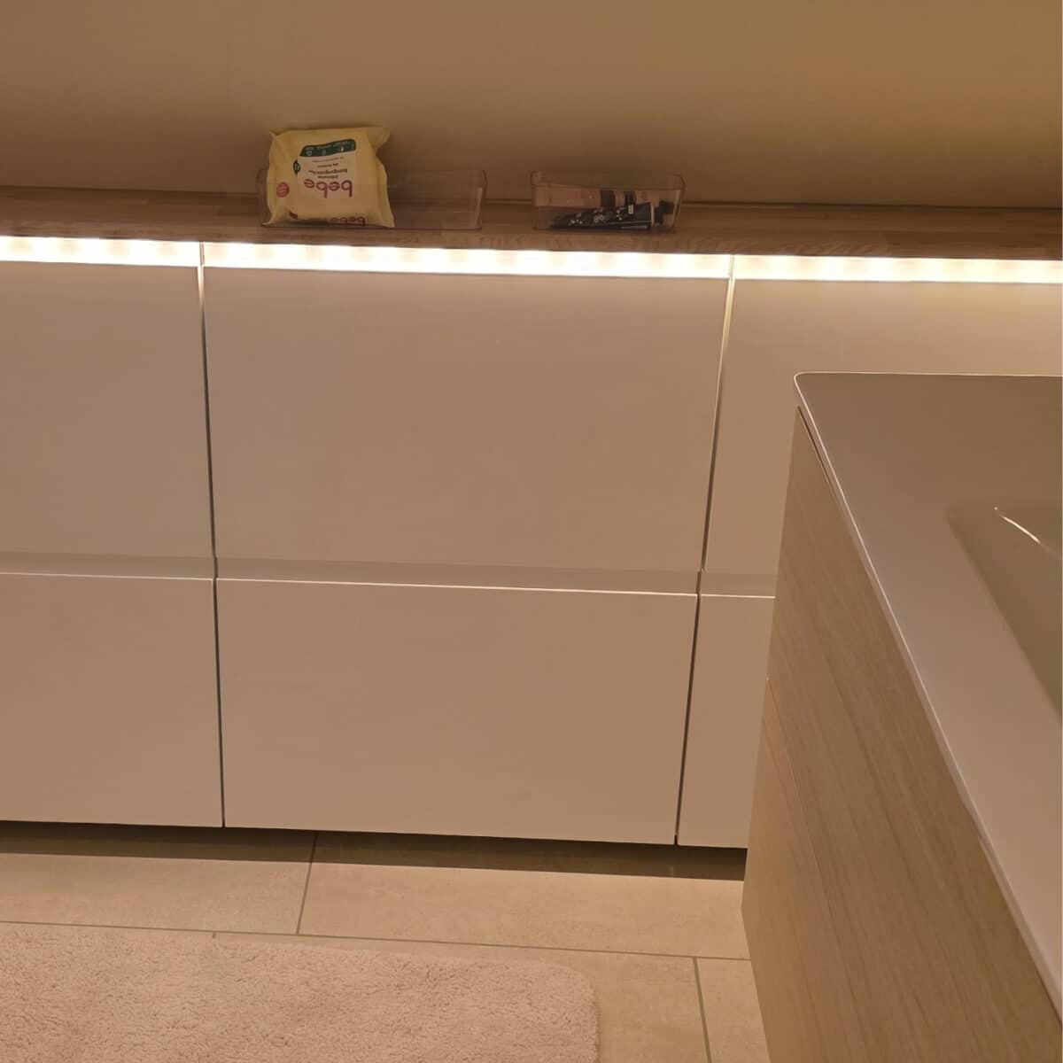 IKEA Kitchen cabinets cut to fit sloped ceilings with added LED lights under the top panel