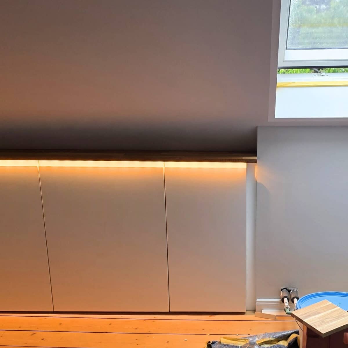 IKEA Kitchen cabinets cut to fit sloped ceilings with added LED lights under the top panel