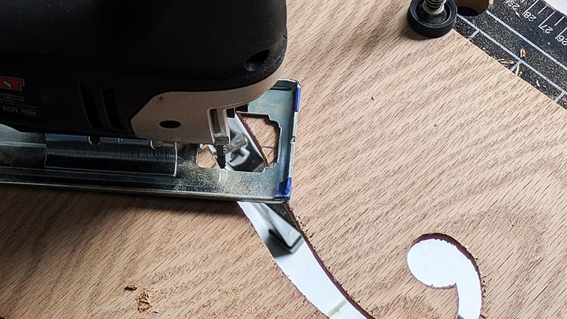 cut the holes - IKEA Hackers Close-up of a metal tool on a wooden workbench with blue tape and a circular hole in the board