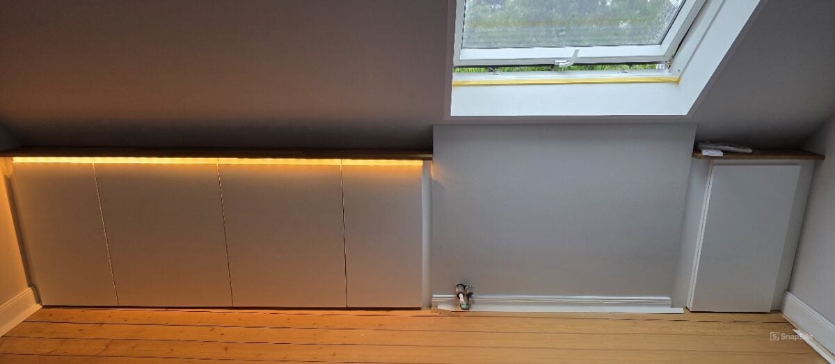 IKEA Kitchen cabinets cut to fit sloped ceilings with added LED lights under the top panel